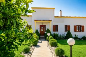 a house with a pathway leading to the front door at Luxury Villa Ntina in Maronia