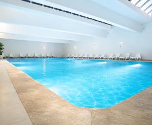 a large swimming pool with chairs in a room at Villa Aglou Center in Zaouia Sidi Ouaggag