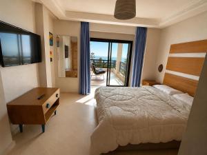 a bedroom with a bed and a view of a balcony at Villa Aglou Center in Zaouia Sidi Ouaggag +12 photos