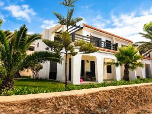 a house with palm trees in front of it at Villa Aglou Center in Zaouia Sidi Ouaggag