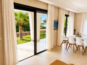 a dining room with a table and a glass door at Villa Aglou Center in Zaouia Sidi Ouaggag
