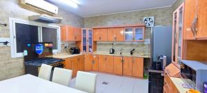a kitchen with wooden cabinets and a refrigerator at La Casa Beduina Hostel in Riyadh