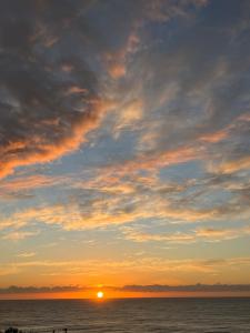 a sunset over the ocean with the sun in the sky at Ocean view on Semple in Kakanui