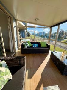 a living room with a couch and some windows at Ocean view on Semple in Kakanui +15 photos