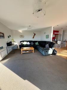 a living room with a couch and a table at Ocean view on Semple in Kakanui