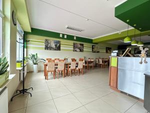 a dining room with green walls and tables and chairs at Pokoje & Bistro Mielec in Mielec