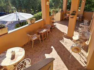 a balcony with tables and chairs and an umbrella at DolceMorfeo in Olbia