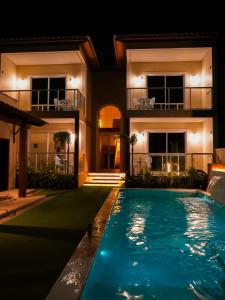 a swimming pool in front of a house at night at My Way Flat in Aracati