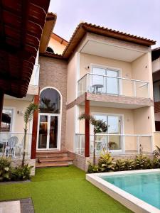 a house with a swimming pool in front of it at My Way Flat in Aracati