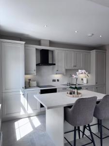 a kitchen with white cabinets and a table with chairs at Studio 4 in Portadown