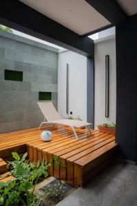 a wooden deck with a white chair on it at Villa BOCANIA in Cotonou