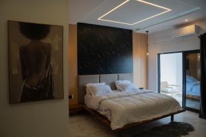 a bedroom with a bed with a painting on the wall at Villa BOCANIA in Cotonou