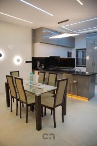 a dining room with a table and chairs and a kitchen at Villa BOCANIA in Cotonou +15 photos