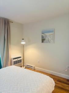 a bedroom with a bed and a painting on the wall at New Cape Cod Condo Near Beaches in Brewster