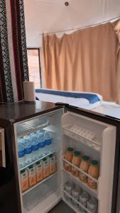 an open refrigerator filled with bottles of water at WADI RUM NASA lUXURY BUBBLE in Wadi Rum