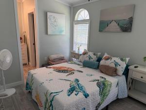 a bedroom with a bed with a comforter on it at Tami Beach Resort Rental in Fort Myers Beach