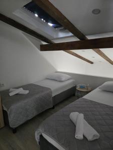 two beds in a room with a ceiling at Villa Adria in Novalja