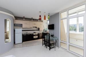 a kitchen with a counter and a table with a chair at Columna Residence in Chişinău