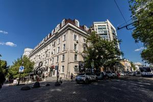 a large white building with cars parked on a street at Columna Residence in Chişinău