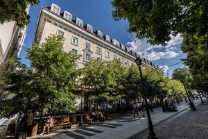 a building on a street with people sitting on benches at Columna Residence in Chişinău