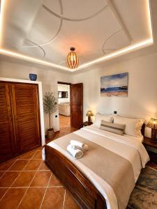 a bedroom with a large bed and a chandelier at Le grand château Vue sur Mer uniquement les familles in Oualidia