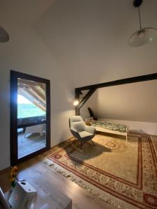 a room with a chair and a bed and a window at Dębinówka in WilczÄ™ta