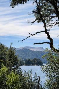 a view of a lake with mountains in the distance at Apart Hotel La Busqueda in Moquehue