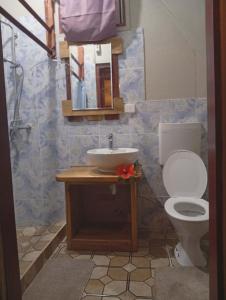 a bathroom with a sink and a toilet at Fortunate Lodge, Restaurant & Bar in Loonékiyawileung