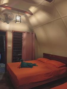a bedroom with a bed with a duck on it at Fortunate Lodge, Restaurant & Bar in Loonékiyawileung