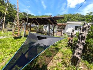 a metal slide in a field with a building at Farm Garden Hotel in Numazu