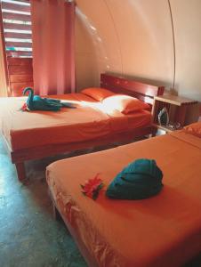 two beds in a room with orange sheets at Fortunate Lodge, Restaurant & Bar in Loonékiyawileung