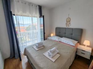 a bedroom with a large bed with towels on it at ĆOSIĆ APARTMANI IGRANE in Igrane