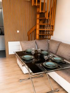 a table with plates and wine glasses on a couch at La Tanière Enchantée de Tréhorenteuc • Brocéliande in Tréhorenteuc
