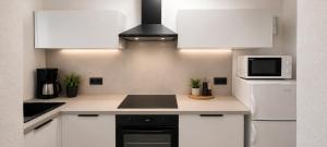 a kitchen with white cabinets and a microwave at Apartments Beba in Privlaka