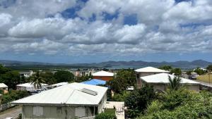 a view of a city with buildings and a cloudy sky at CHAMBRE Calme et Bien située in Le Lamentin