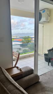 a chair in a room with a view of the ocean at CHAMBRE Calme et Bien située in Le Lamentin