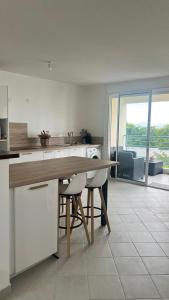 a kitchen with a wooden table and chairs in it at CHAMBRE Calme et Bien située in Le Lamentin