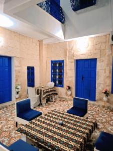 a room with blue doors and a table and chairs at Dar Aziz in Sousse