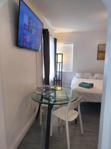 a small room with a glass table and a bed at Beautiful and Equipped Studio H in Hollywood