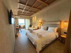 a bedroom with a large white bed in a room at Ariadne Beach in Platanias +104 photos