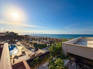 a view of a resort with chairs and umbrellas and the ocean at Ariadne Beach in Platanias