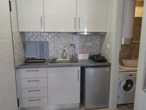 a small kitchen with white cabinets and a sink at Lana in Paralia Katerinis +17 photos