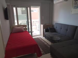 a living room with a couch and a red blanket at Lana in Paralia Katerinis
