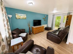 a living room with a couch and a television at 47 Trevithick Court in Hayle
