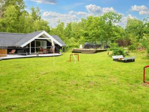 a large yard with a house and a playground at Bright Cottage with Hot Tub in Ebeltoft