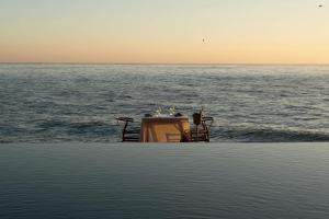 a boat in the ocean at sunset at Vela Tianyar Boutique Resort - Oceanfront in Tianyar