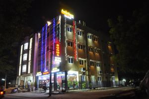 a building with lights on the side of it at night at Hotel New Amirtham inn in Palani