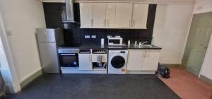 a kitchen with a stove and a washer and dryer at King Suite in Ipswich