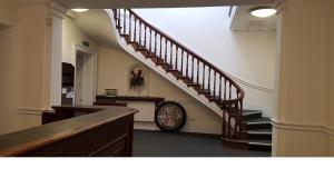 a hallway with a staircase and a clock in a building at King Suite in Ipswich