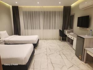 a hotel room with two beds and a television at Boutique Hotel El Mesaadia in Cairo
